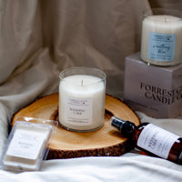 Candles Forrest Glen Candle Co on a wooden board with a neutral background.