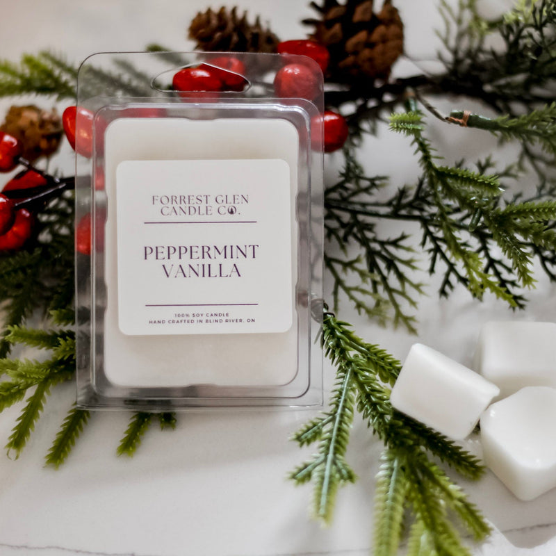 Peppermint Vanilla wax melt package with Christmas decorations on a white surface