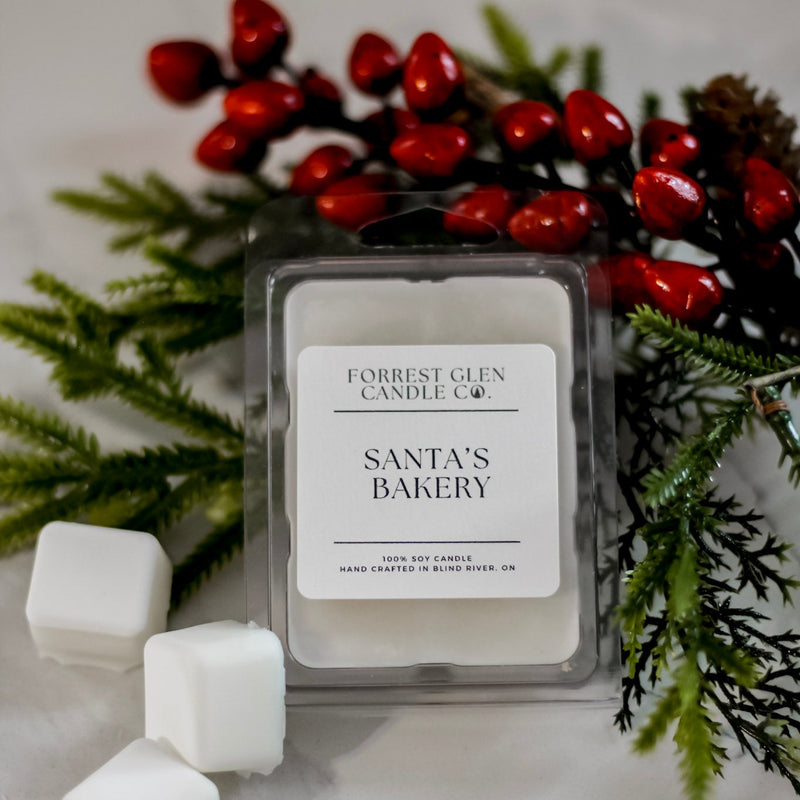 Scented soy wax melts labeled 'Santa's Bakery' with Christmas decorations.