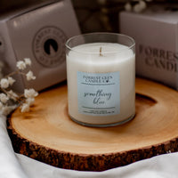 Candle labeled 'something blue' on a wooden surface with a blurred background