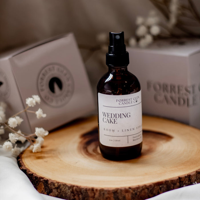 Bottle of 'Wedding Cake' room and linen on a wooden surface with blurred background